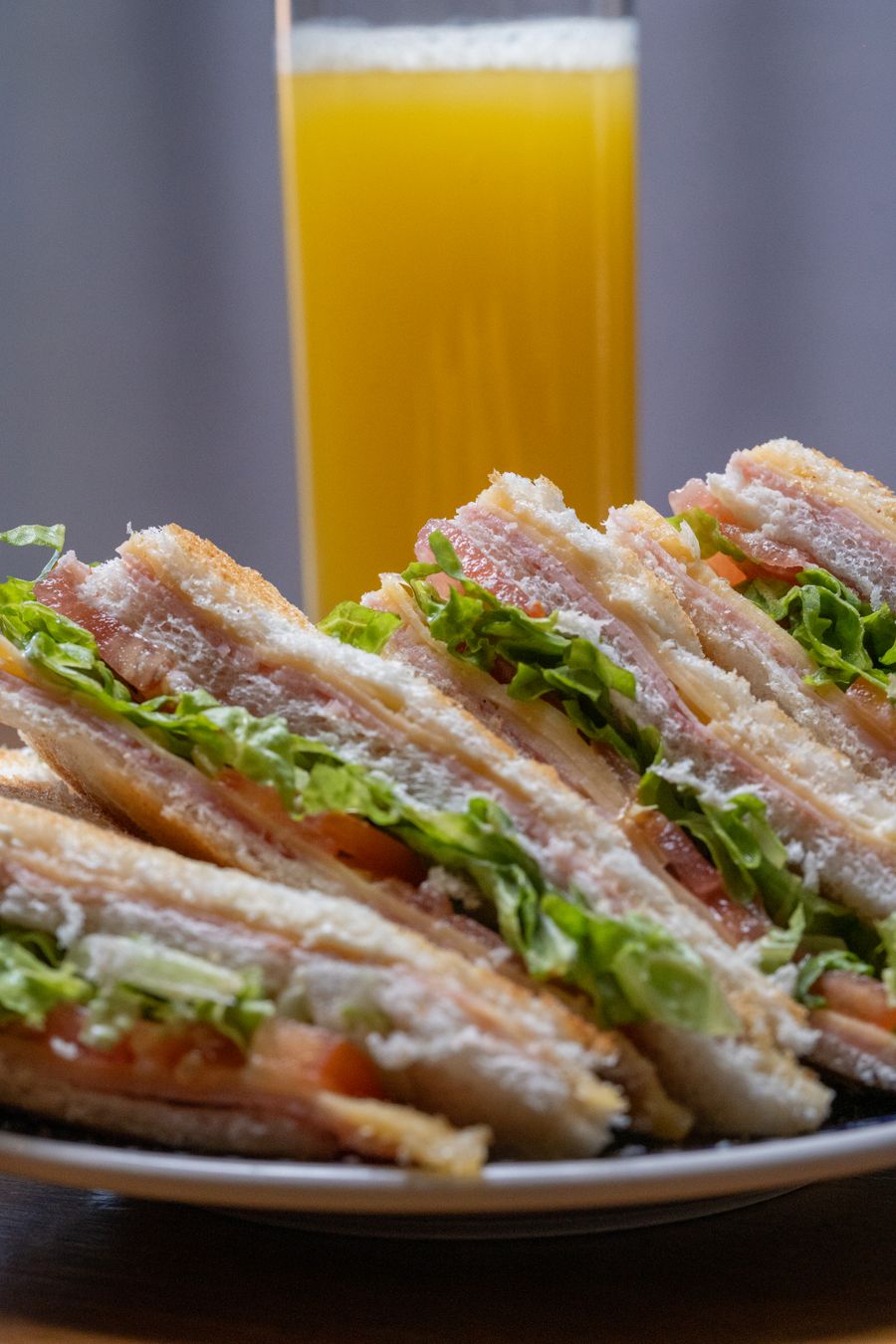 Layered South Bay Club sandwich with turkey, ham, bacon, lettuce and tomato